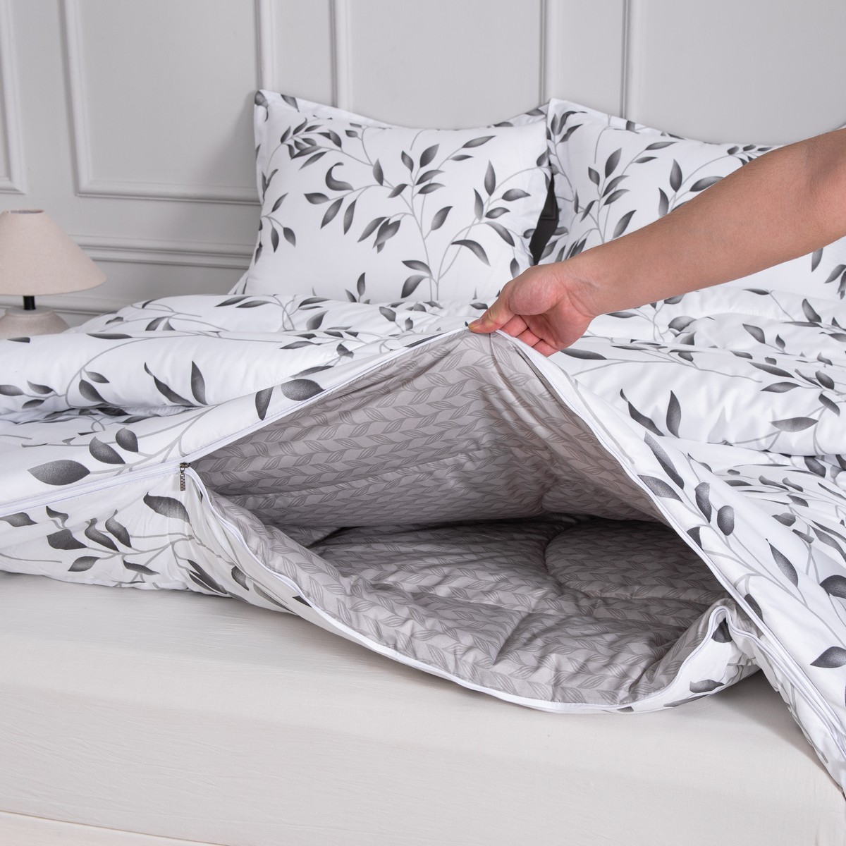 Een hand ritst de delen van vierseizoenen dekbed Nora aan elkaar, ideaal om de warmte eenvoudig aan te passen.