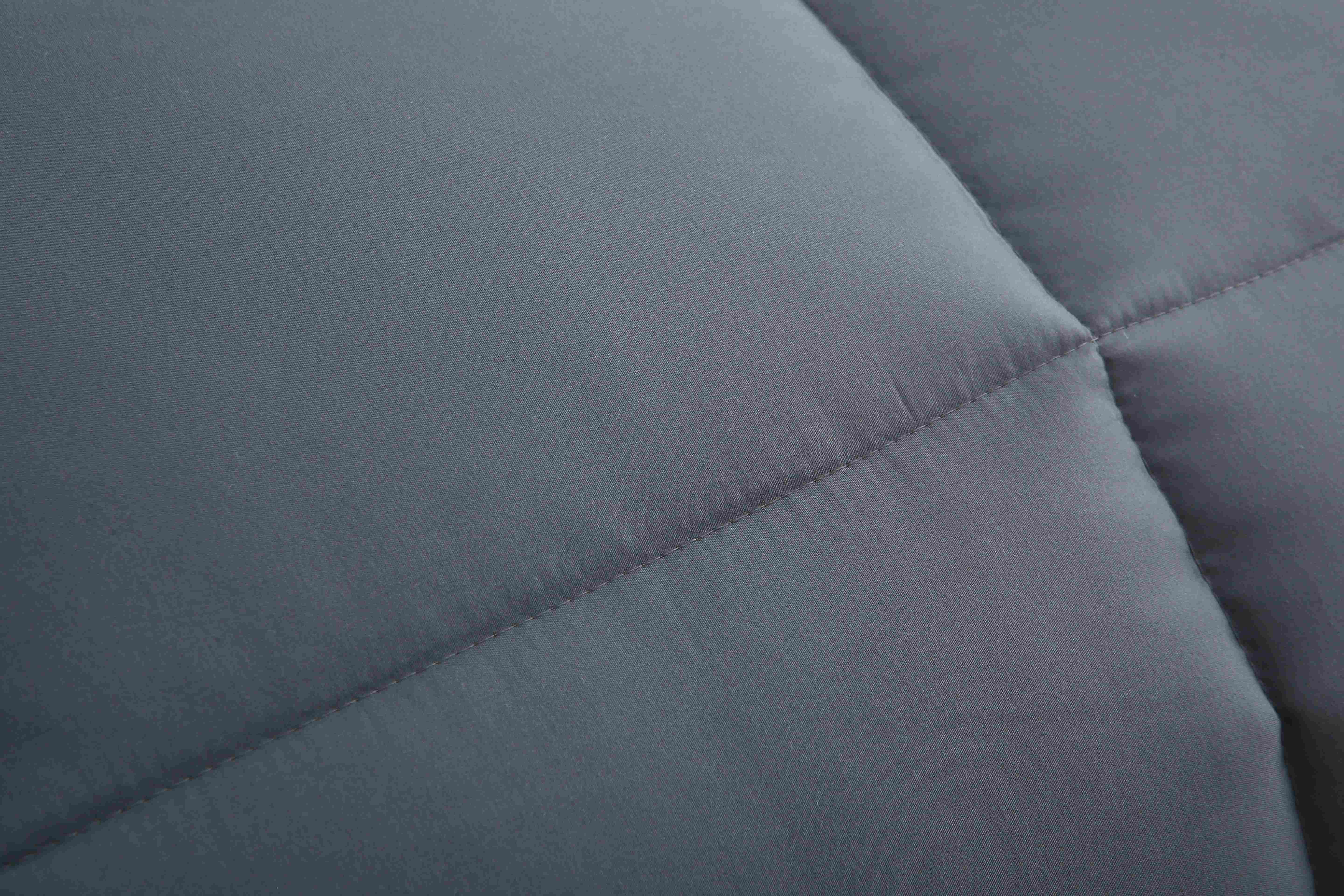Detail van de stiknaad en stof van het antraciet dekbed zonder overtrek