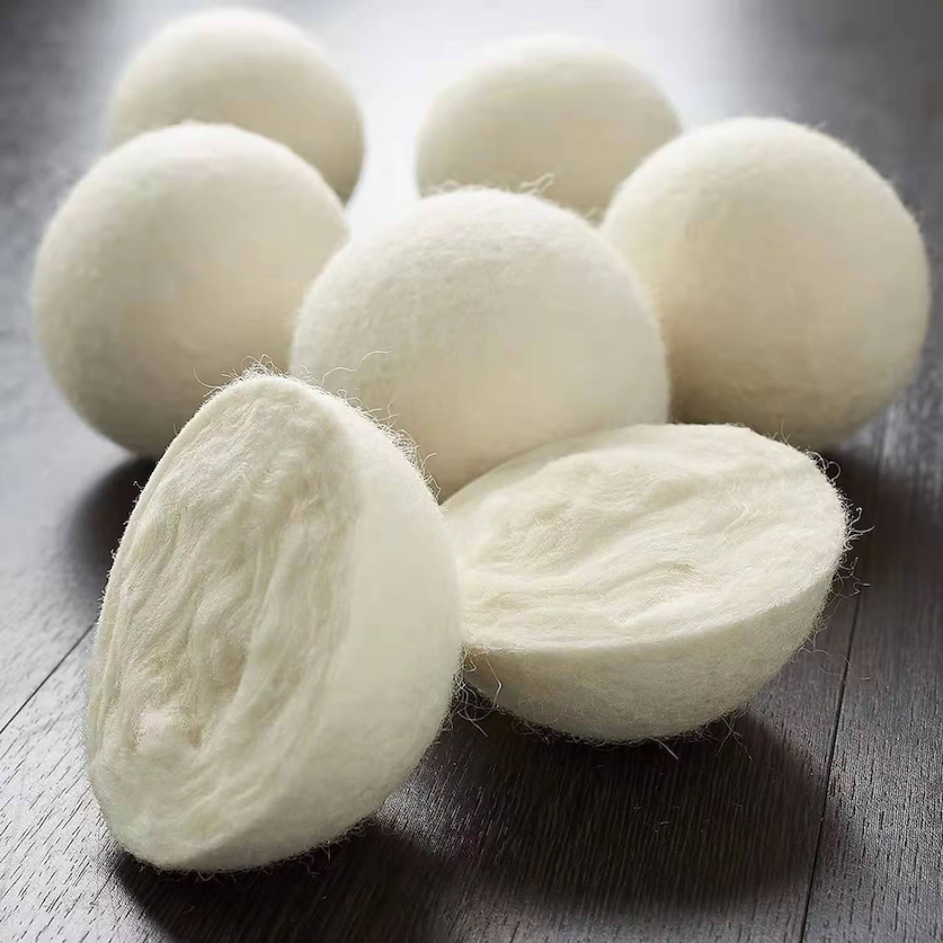 100% wollen drogerballen waarbij één bal is opengesneden om de compacte wolstructuur aan de binnenkant te tonen.
