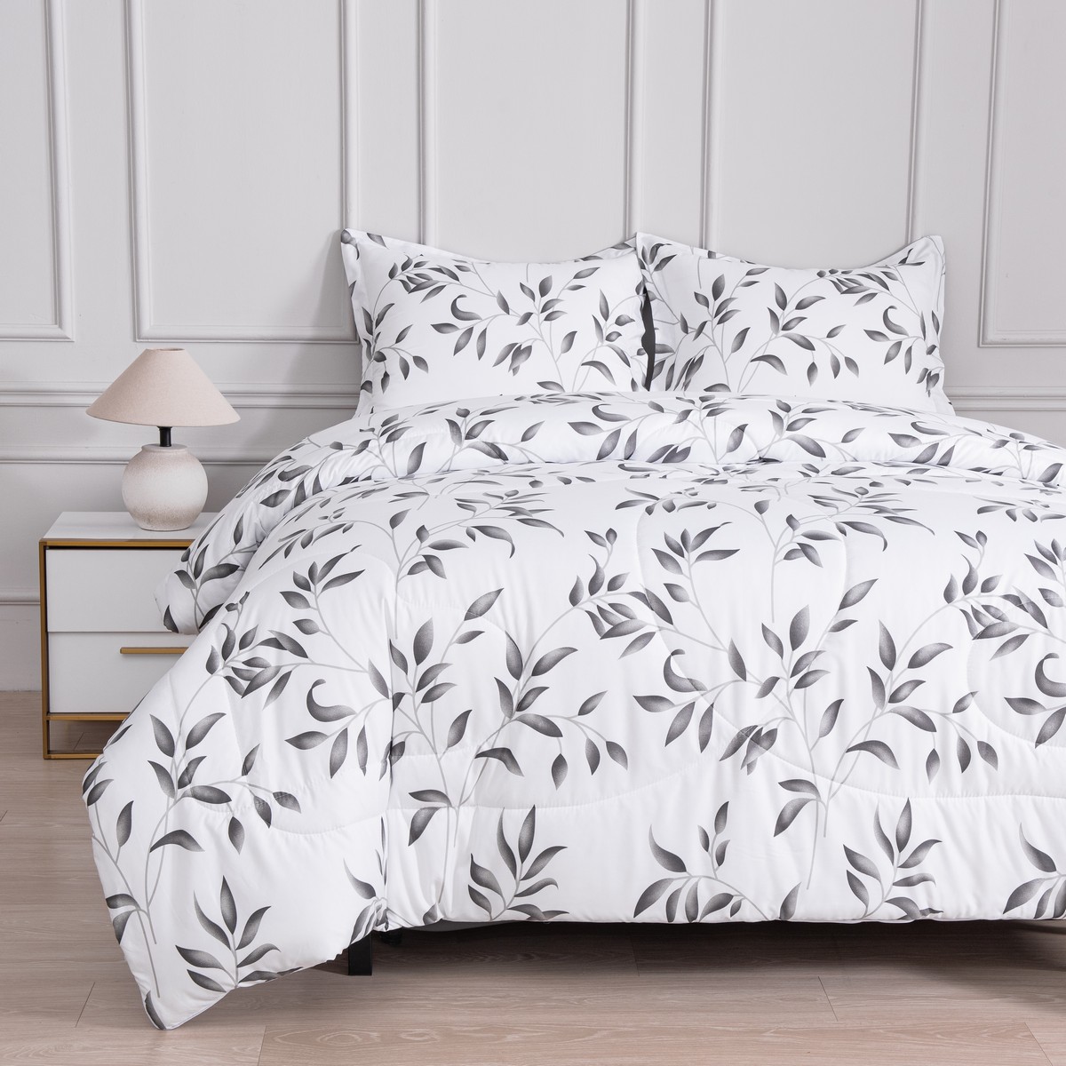 Bed met 4‑seizoenen dekbed zonder overtrek waarvan beide lagen in de vaste overtrek zitten met bladpatroon.