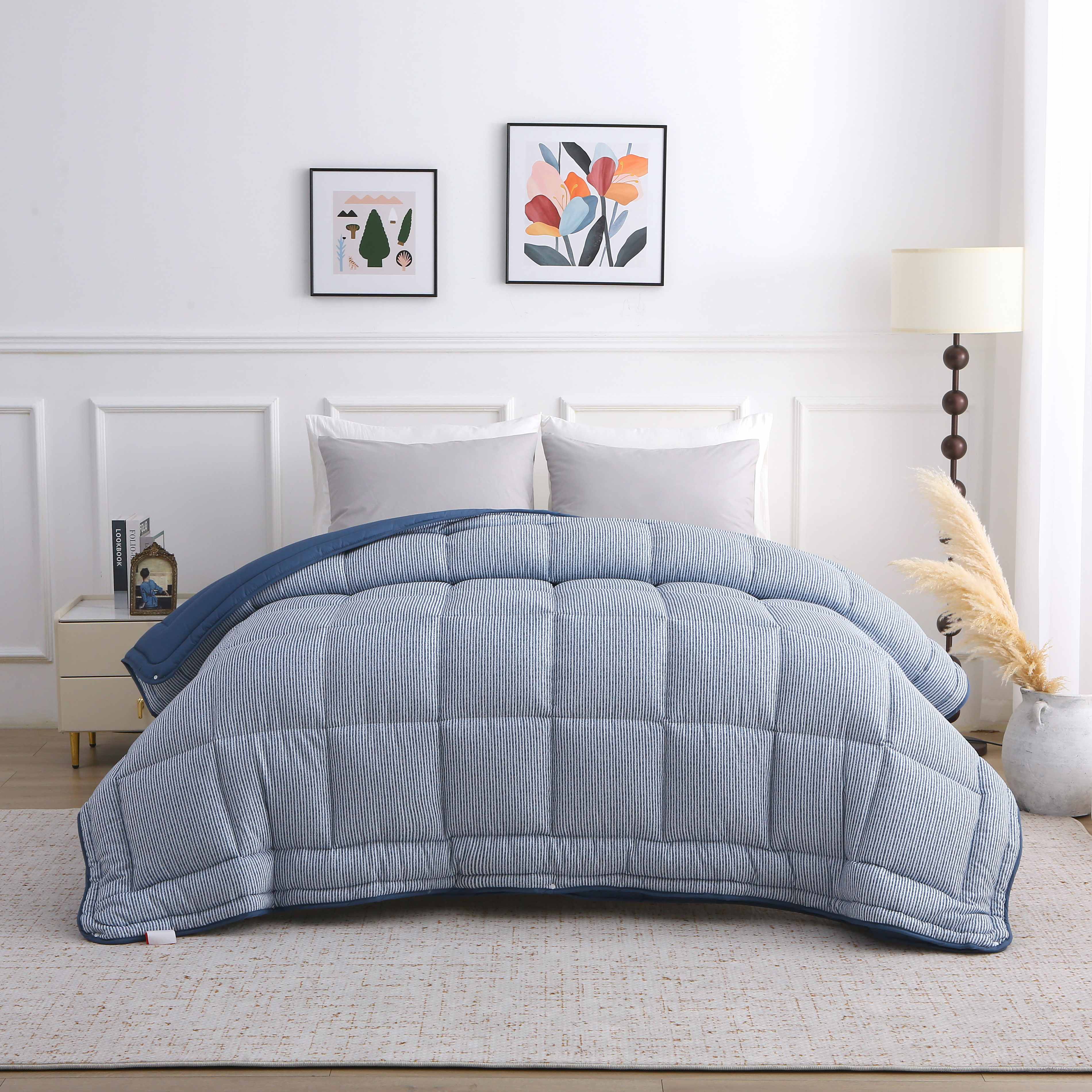 Het volledig opgemaakte bed met het blauwe 4-seizoenen dekbed met vaste hoes, zichtbaar in geruite stikstructuur.