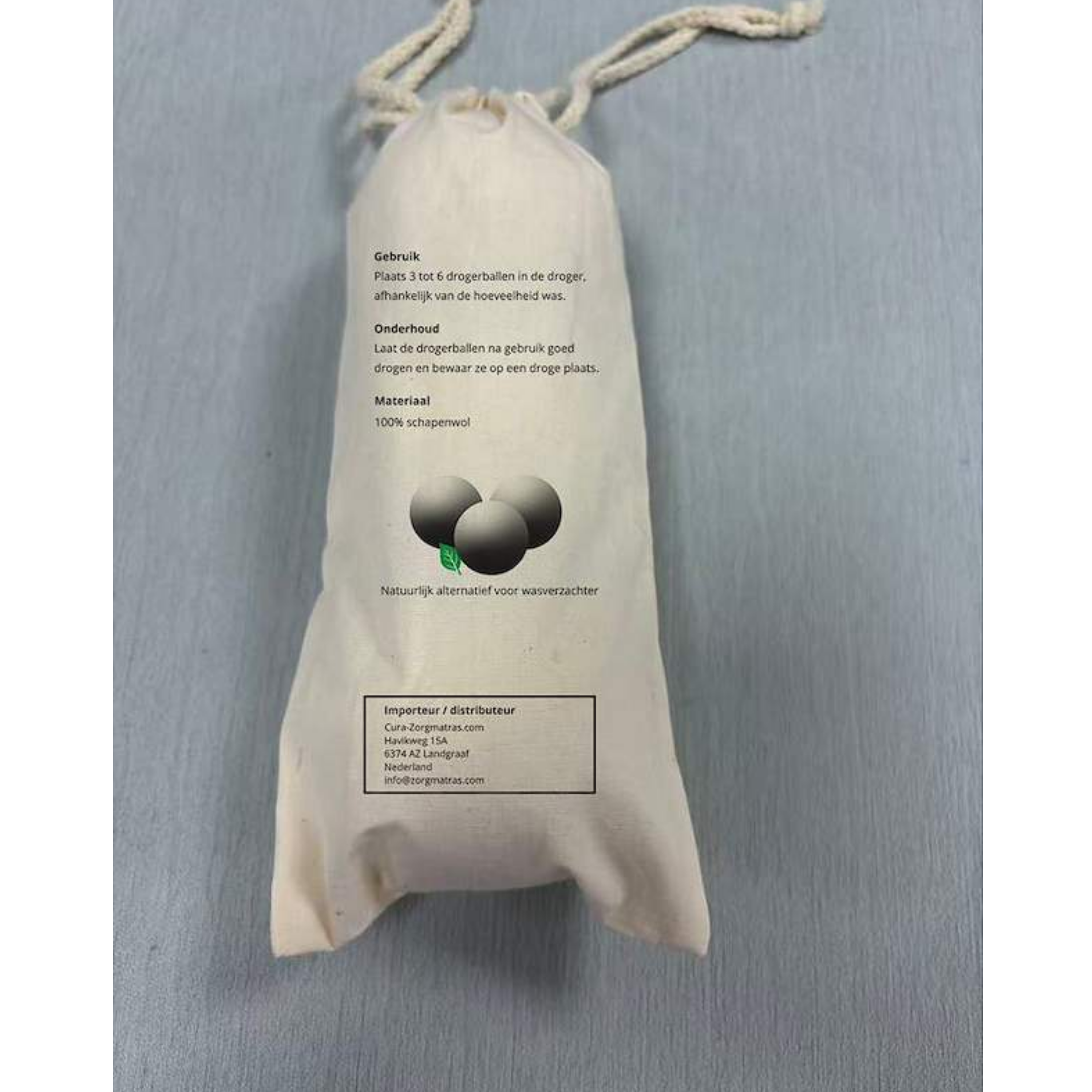 Achterkant van de katoenen opbergzak voor wollen drogerballen met gebruiks-, onderhouds- en materiaalinformatie.