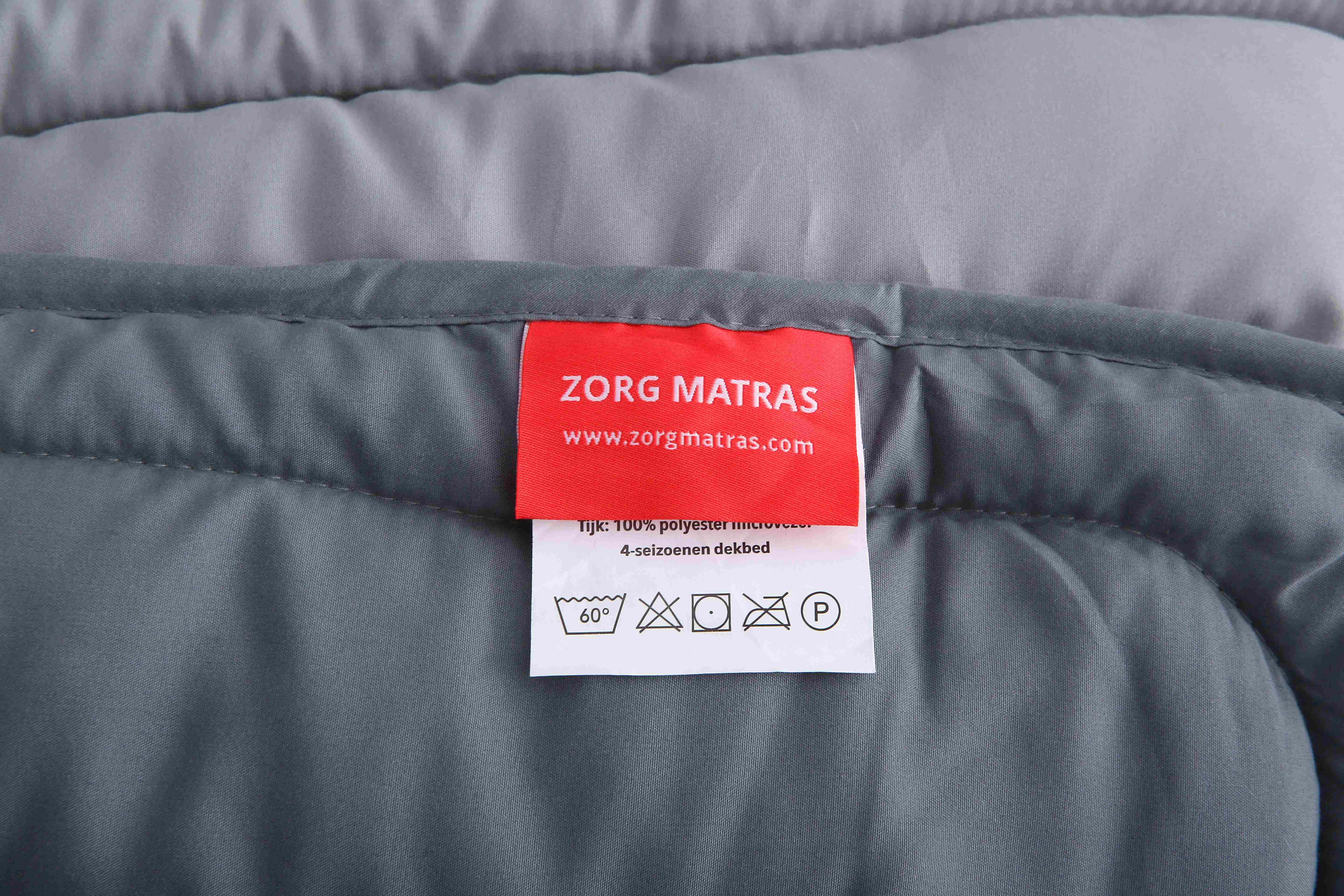 Label van antraciet dekbed zonder overtrek met logo van Zorgmatras