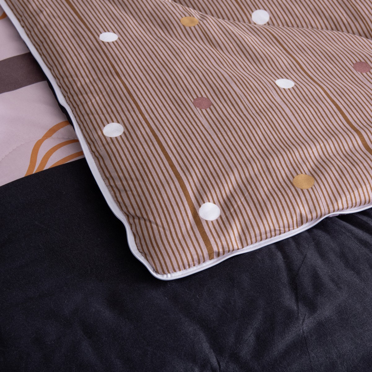 Emma dekbed opengeklapt waarbij de binnenzijde met bruine strepen en witte stippen worden getoond.