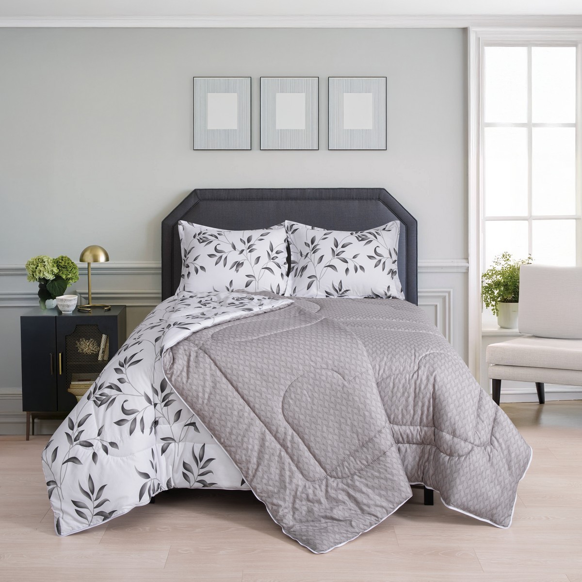 Ruime slaapkamer met tweedelig ritsbaar vierseizoenen dekbed met bladpatroon en grijze binnenlaag op het bed.