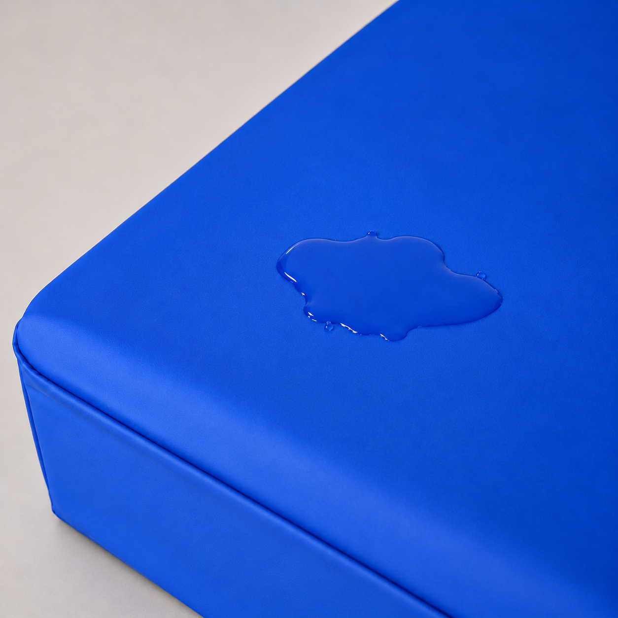 Waterdruppels blijven op de waterdichte blauwe matrashoes liggen zonder in te trekken.