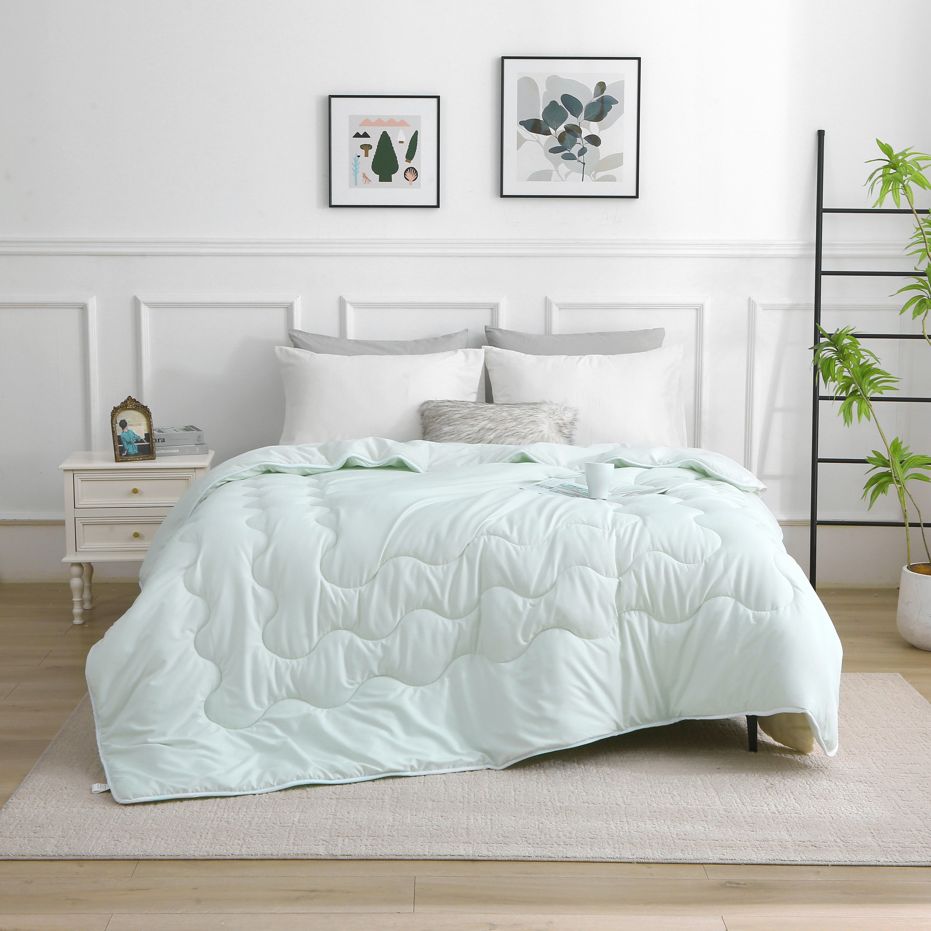 Lichtgroen verkoelend dekbed zonder overtrek, opgemaakt op bed in lichte slaapkamer, ideaal bij nachtzweten