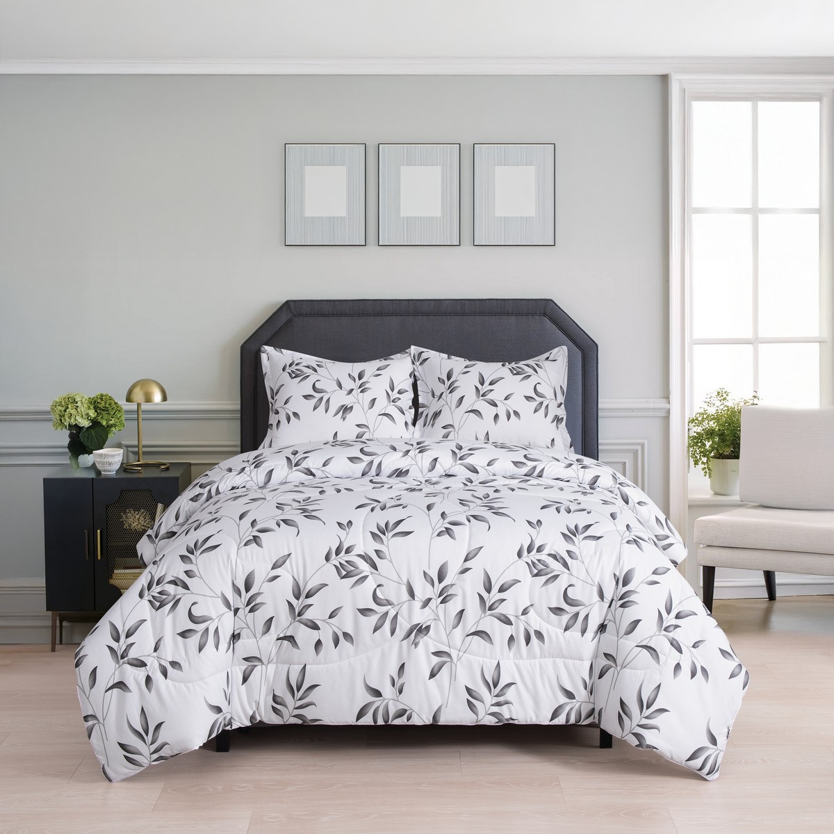 Volledig opgemaakt bed in een moderne slaapkamer met het tweedelige 4‑seizoenen dekbed Nora in wit met grijze bladeren en een elegante donkergrijze hoofdbord.