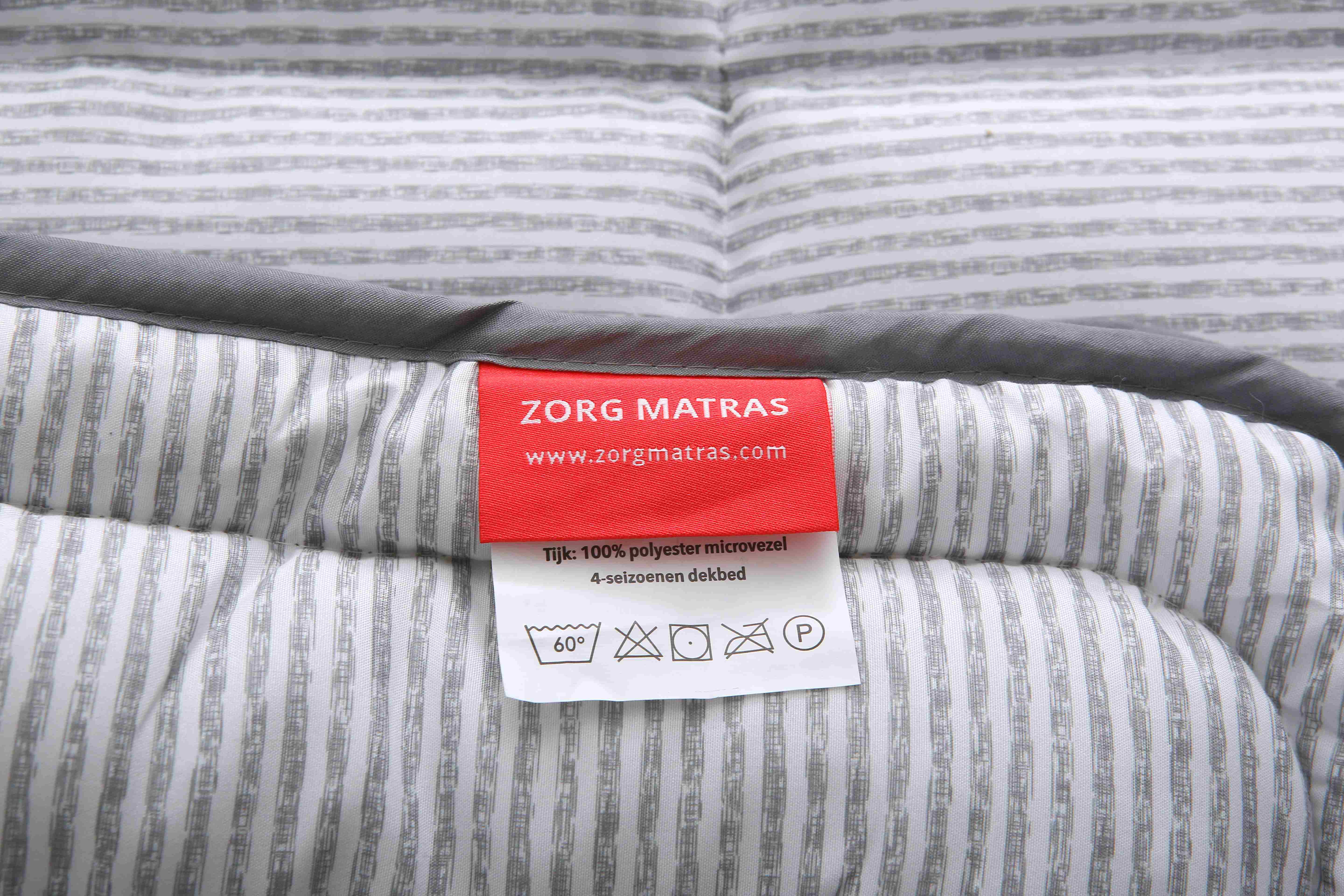 Detailfoto van het waslabel met onderhoudsinstructies van het 4-seizoenen dekbed van Zorgmatras