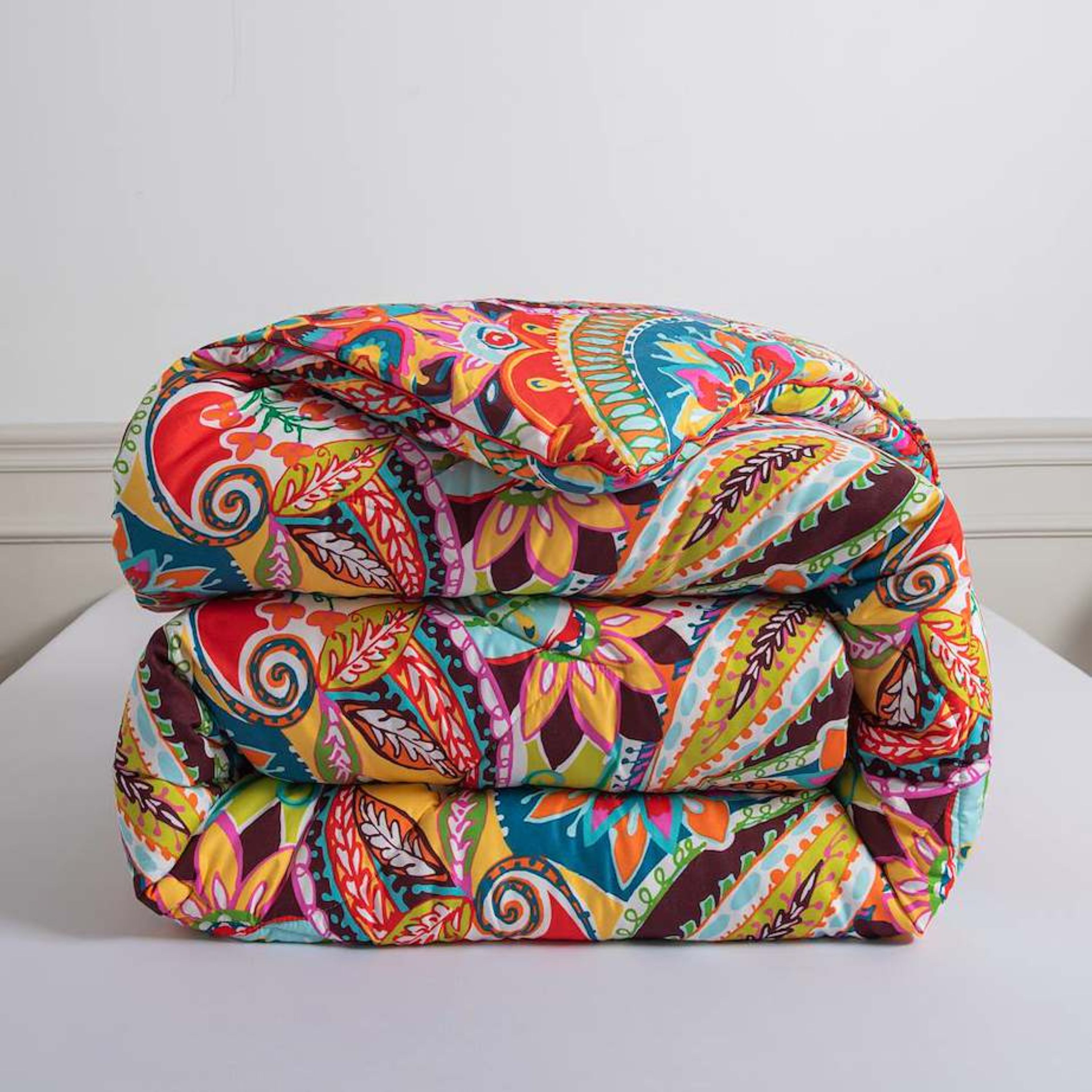 Opgevouwen Happy zomerdekbed zonder hoes met kleurrijke print en zachte polyester stof.